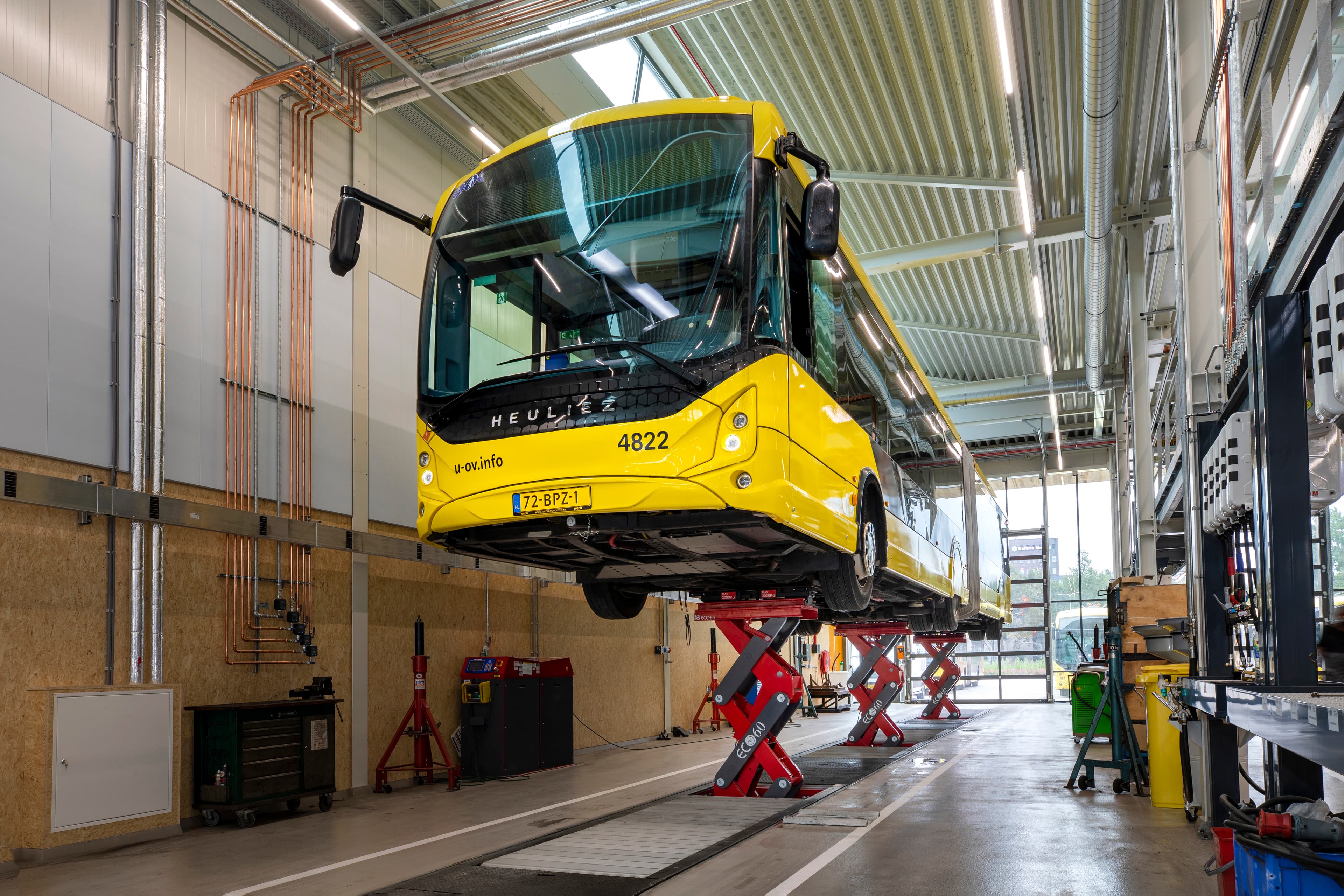 Public transport buses undergoing service in the depot using in-ground lifts.