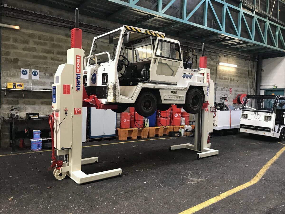 GSE ground support equipment in a workshop lifted for inspection and maintenance with Stertil-Koni mobile column vehicle lifts
