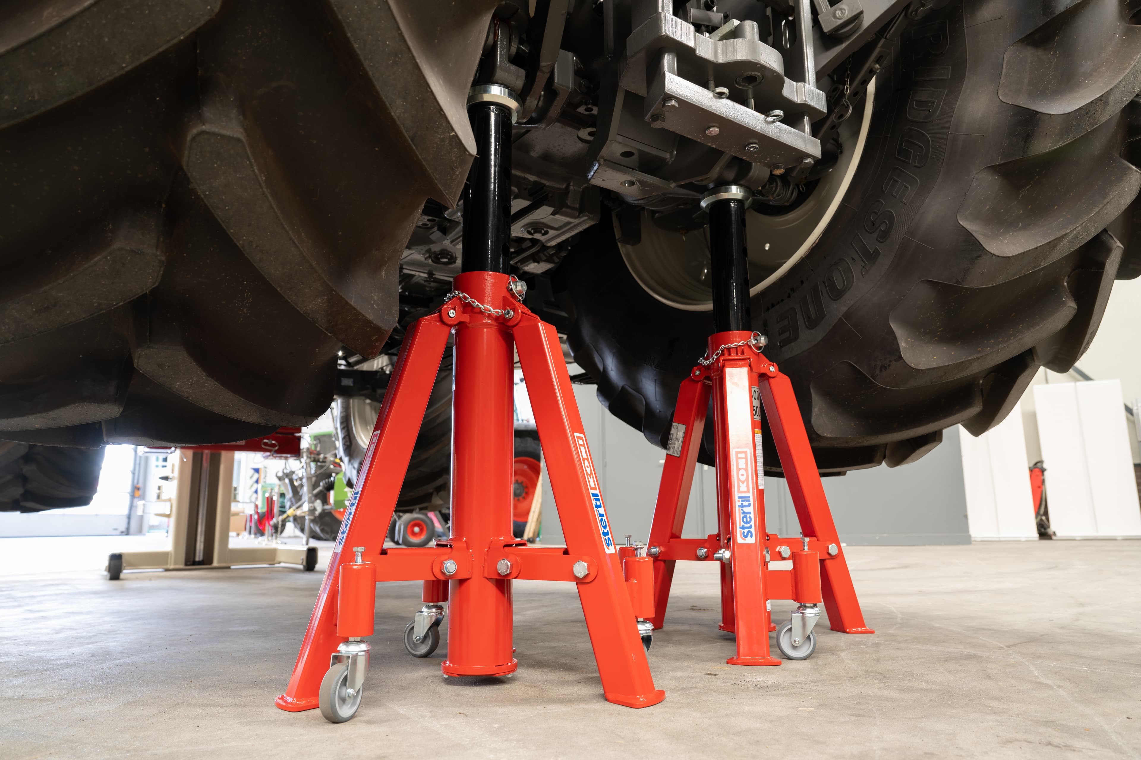 Stertil-Koni axle stands underneath a lifted tractor for extra support in the workshop